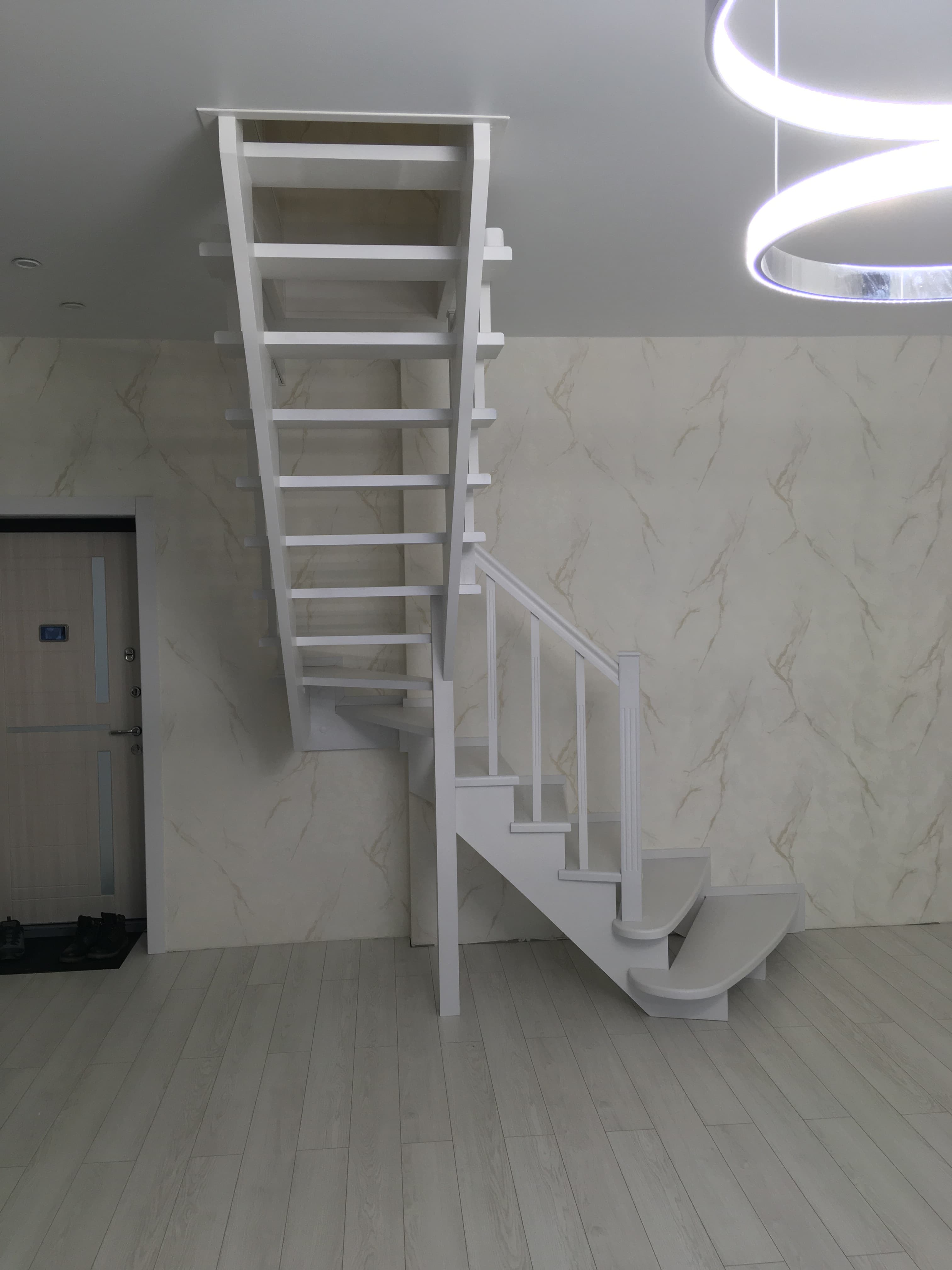 Компактная лестница в двухуровневой квартире вид из под лестницы