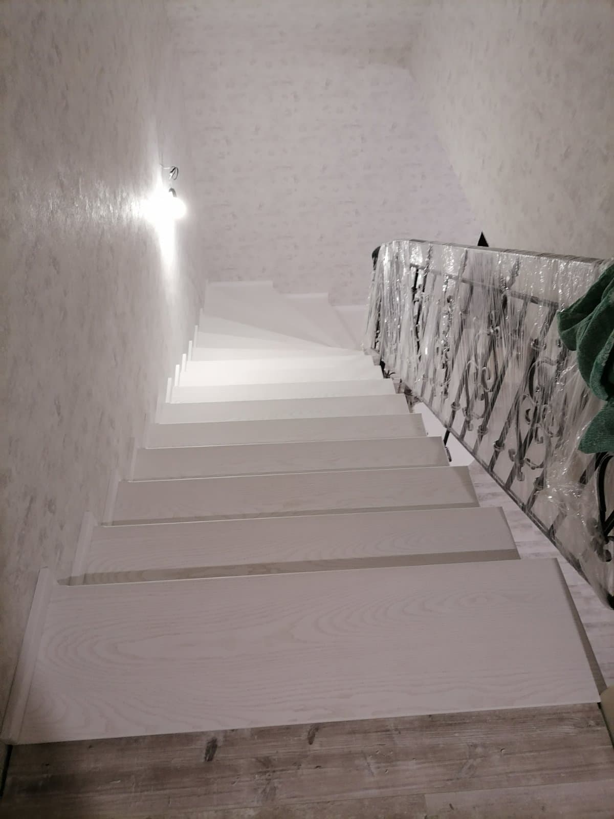 Ступени с яркими порами древесины ясеня на лестнице - вид со второго этажа