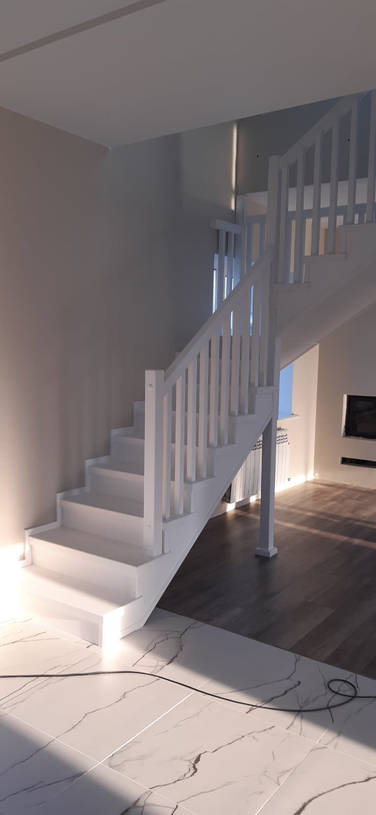 Вид на легкую лестницу на металлокаркасе с первого этажа